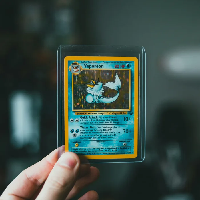 A graded Vaporeon card held up to the light