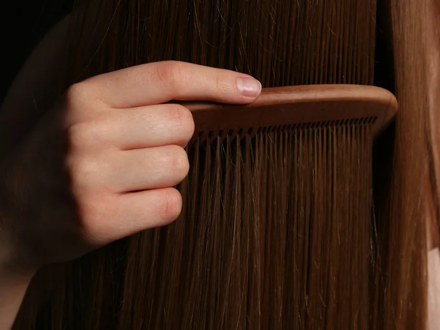 A comb being drawn through long smooth hair