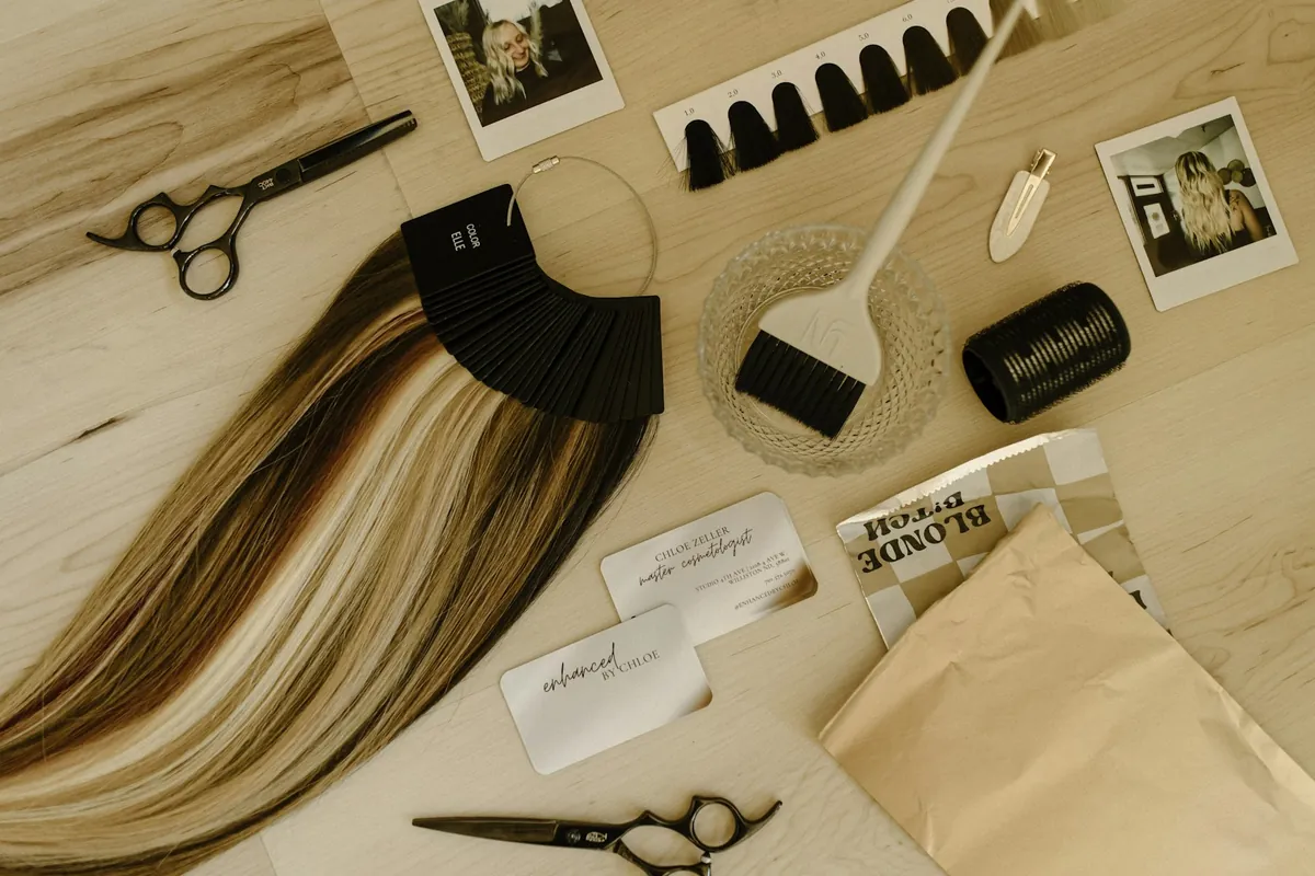 Extension wefts laid out beside colour swatches, sectioning clips and shears