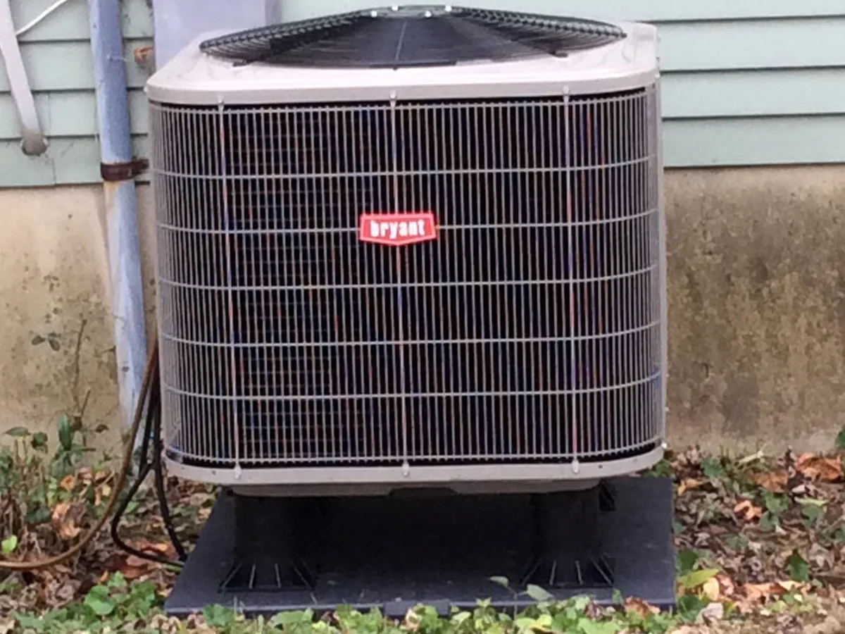 New high-efficiency Bryant condenser installed on a level composite pad after replacement