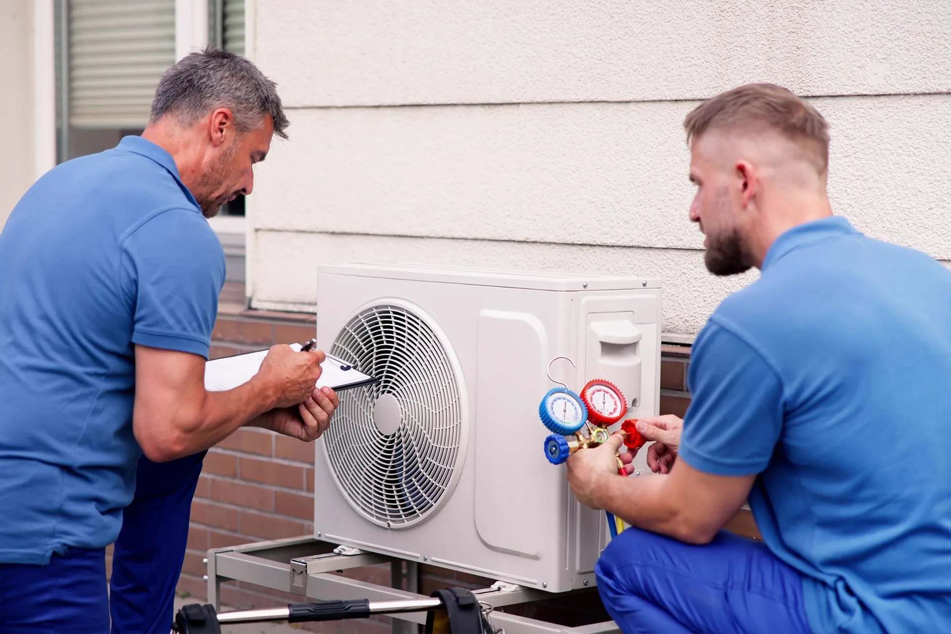 Two Altus Air technicians servicing an outdoor air conditioning condenser unit