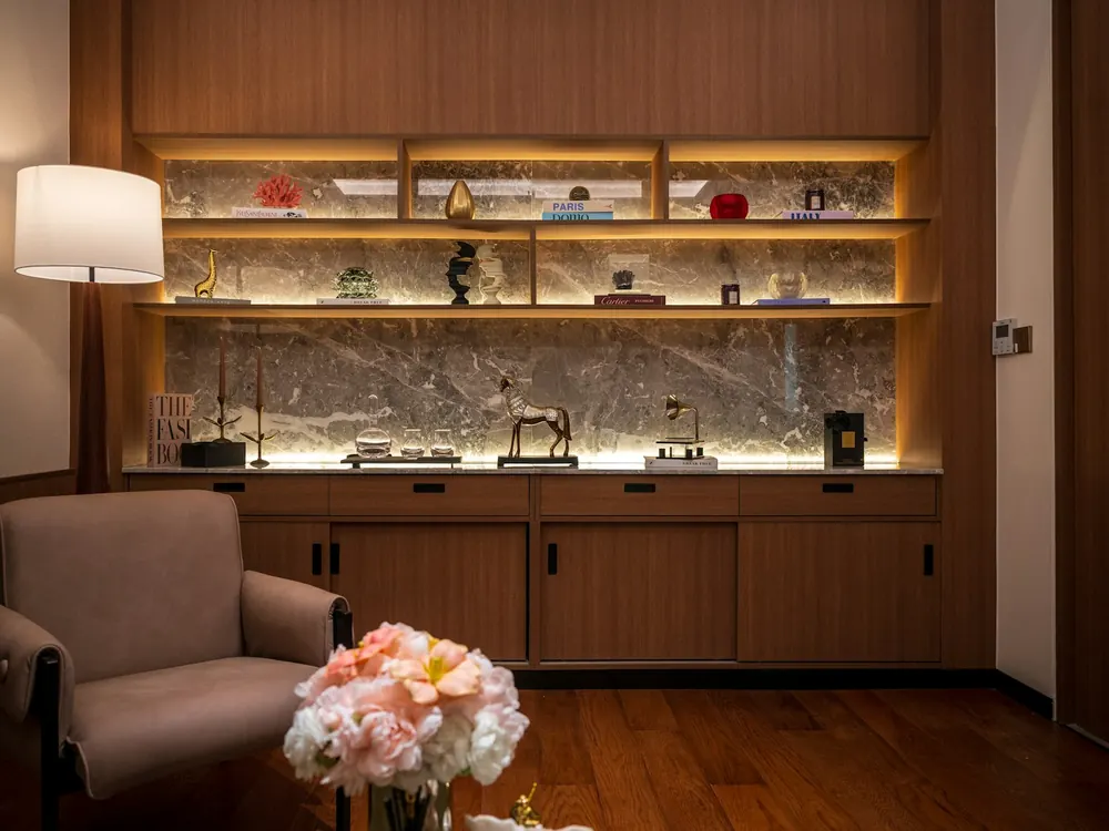 Softly lit shelving with skincare products and fresh flowers
