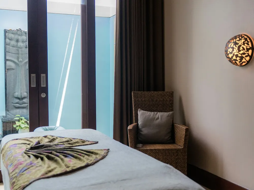 Private treatment room with soft daylight and a made-up treatment bed