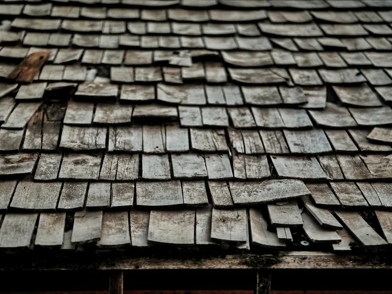 Badly worn and curling wooden roof shingles