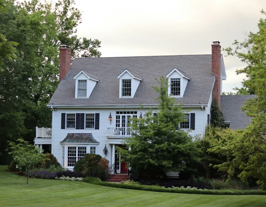 Two-storey home with a new green metal roof and brick chimney